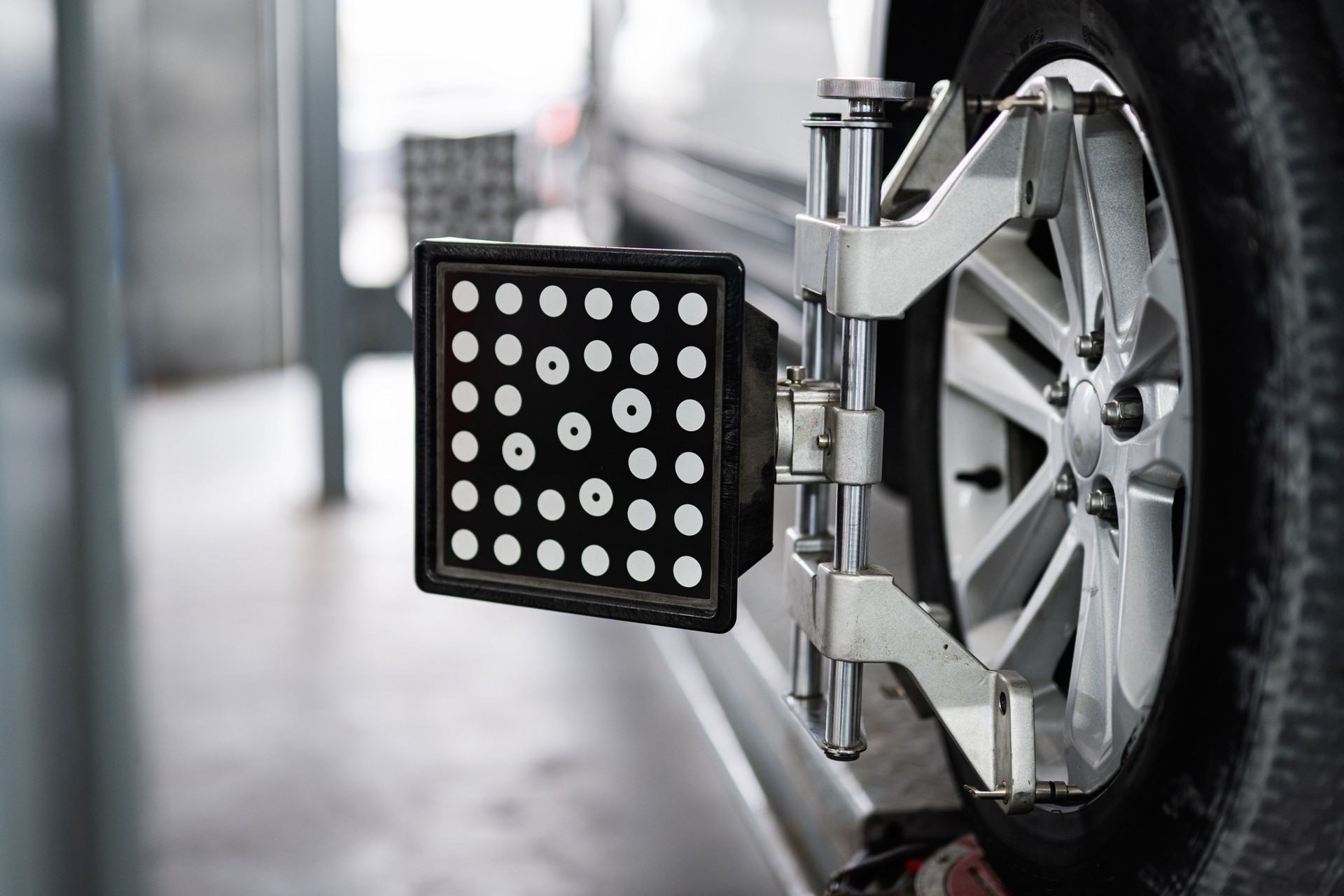 Car wheel alignment with specialized equipment in auto repair shop