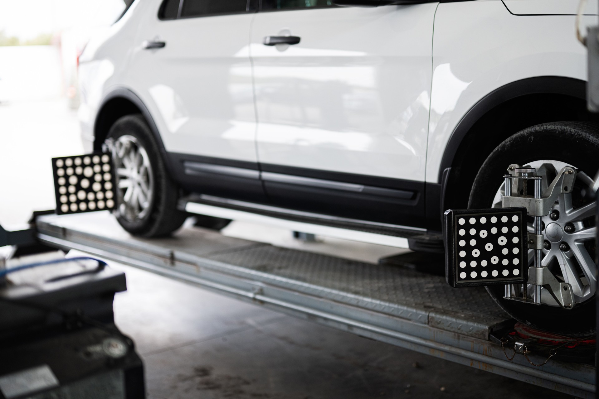 Car on lift for wheel alignment service in auto shop